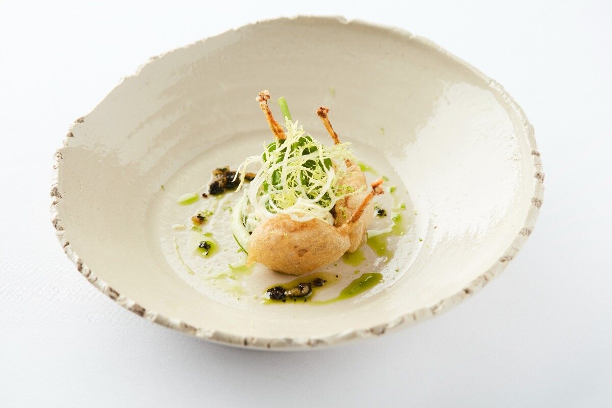 Delicately plated dish with frisée and herb oil at Restaurant De Jonkman